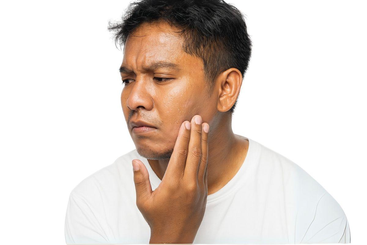 Pria yang memegang kulit wajahnya yang kering