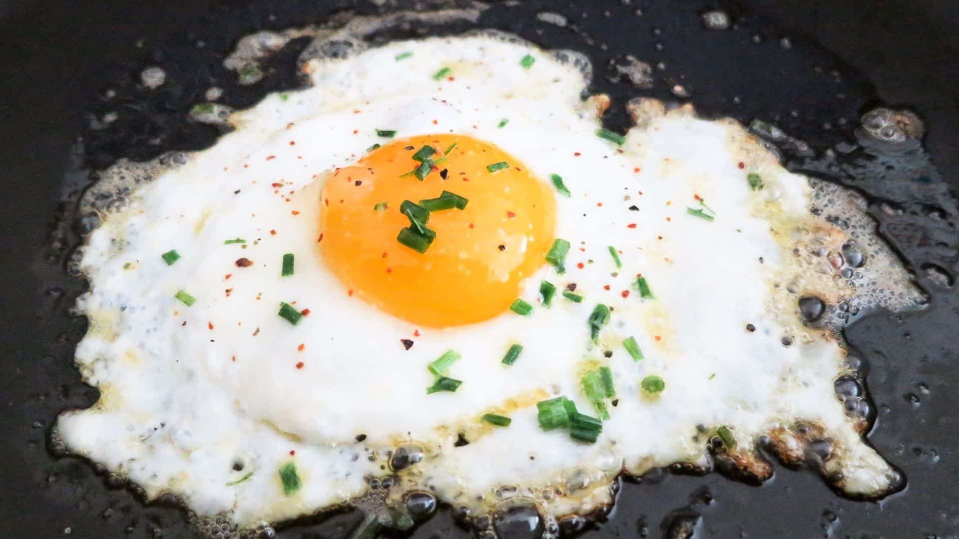 Close-up telur ceplok atau sunny side egg dengan taburan oregano diatasnya