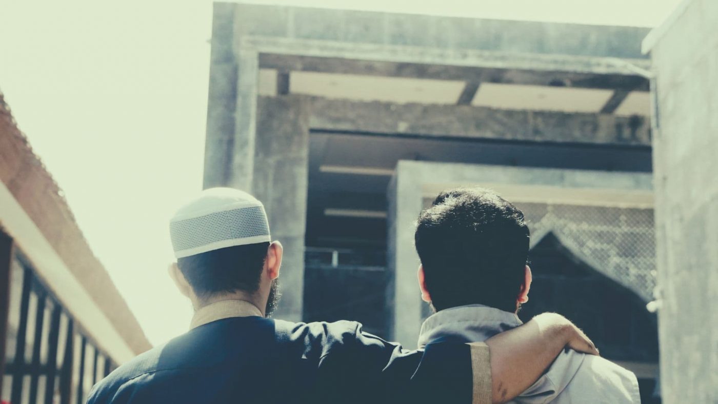 Dua orang pria sedang berjalan menuju masjid.
