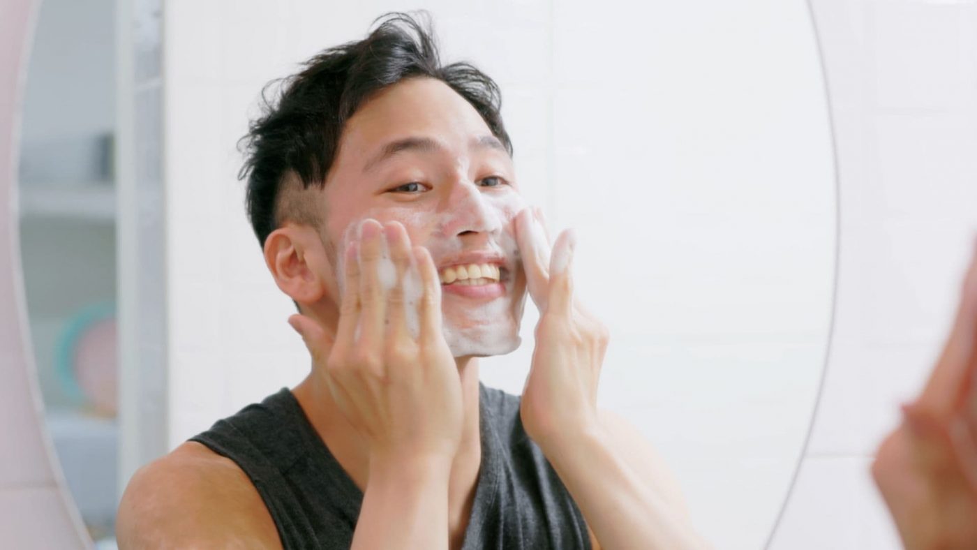 Laki-laki mencuci muka untuk menghilangkan komedo